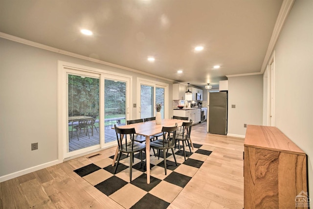 dining room featuring light hardwood / wood-style flooring and ornamental molding