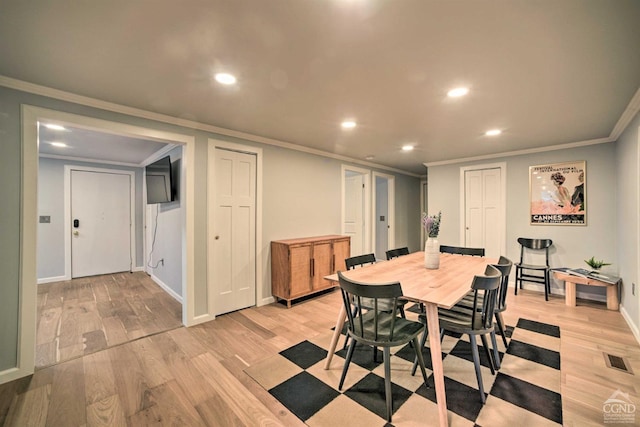 dining room with light hardwood / wood-style floors and ornamental molding