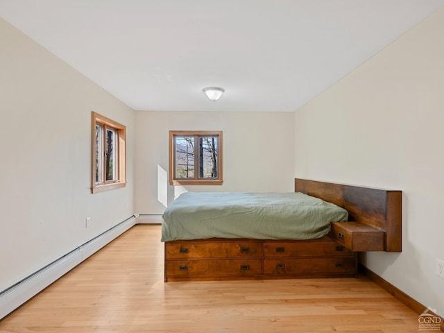 bedroom with light hardwood / wood-style floors and a baseboard radiator