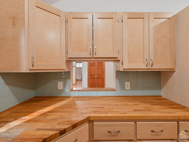 kitchen with wood counters, decorative backsplash, and light brown cabinetry