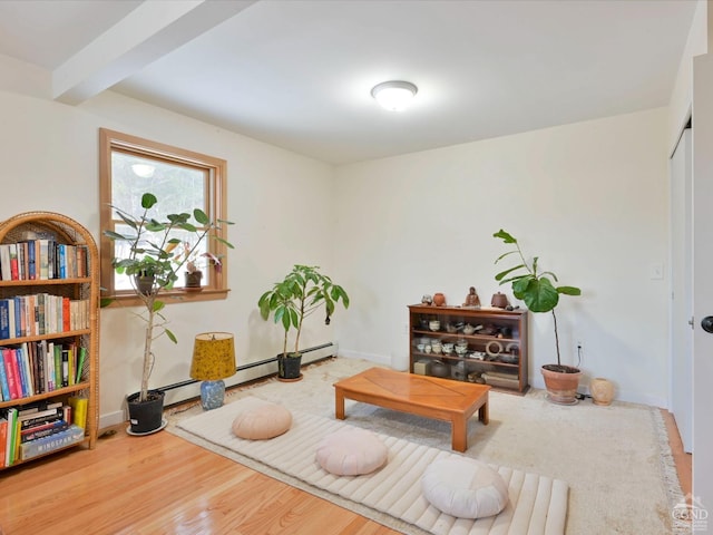 living area with beamed ceiling, wood-type flooring, and a baseboard radiator