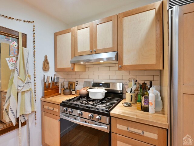 kitchen featuring stainless steel gas stove, wood counters, decorative backsplash, and light brown cabinetry