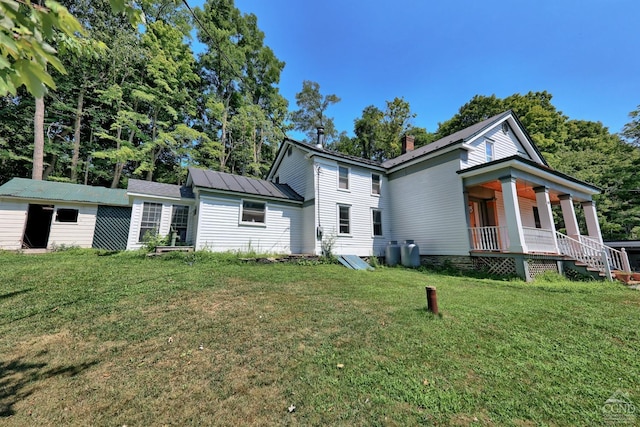 back of house with a lawn and covered porch