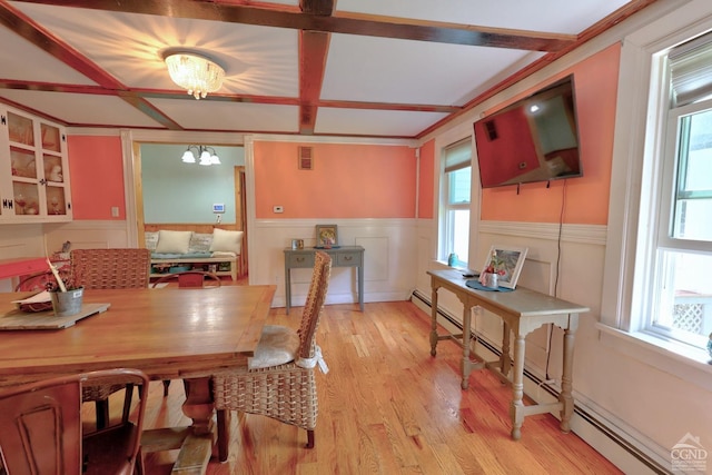 dining space with light hardwood / wood-style floors and an inviting chandelier