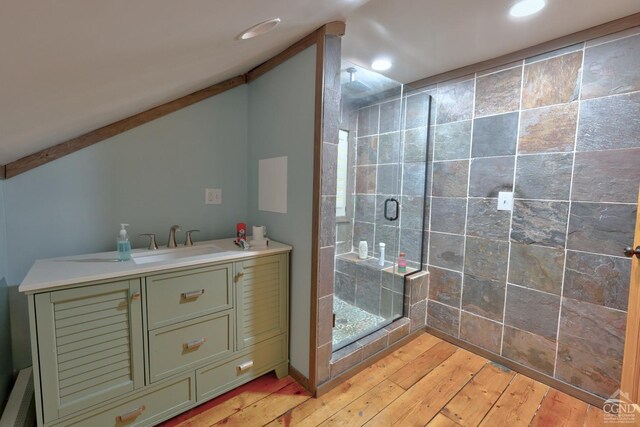 bathroom featuring hardwood / wood-style flooring, vanity, an enclosed shower, and vaulted ceiling