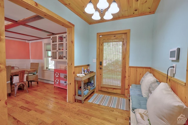 entryway with crown molding, light hardwood / wood-style floors, a baseboard radiator, and an inviting chandelier