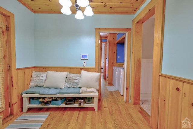 hall featuring wood ceiling, independent washer and dryer, light hardwood / wood-style floors, and a notable chandelier