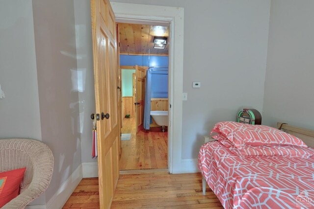 bedroom with light hardwood / wood-style floors and wood ceiling