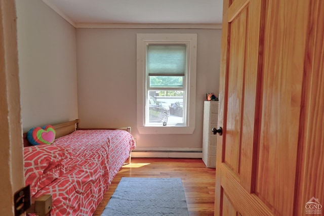 bedroom featuring light hardwood / wood-style floors and baseboard heating