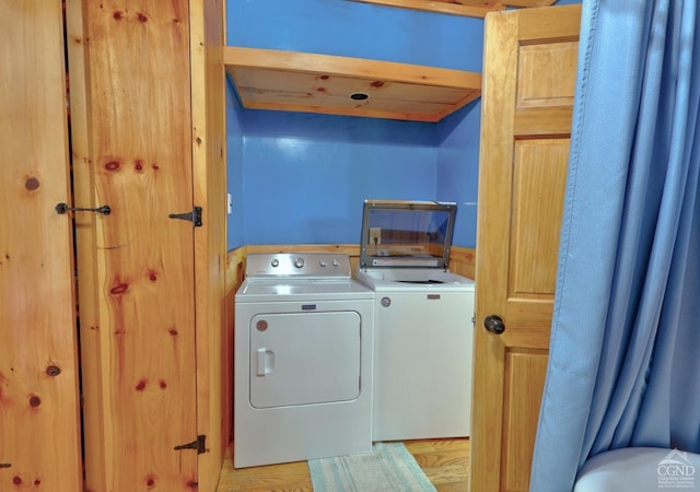 washroom featuring light hardwood / wood-style floors and washing machine and clothes dryer