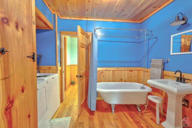 bathroom featuring washing machine and dryer, wooden ceiling, wooden walls, and wood-type flooring