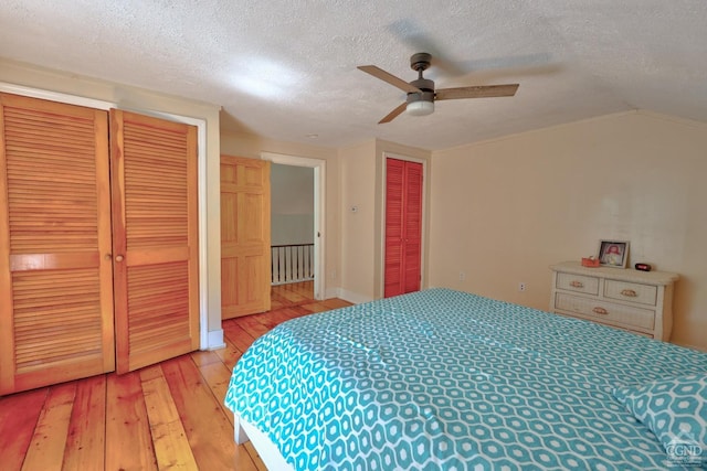 bedroom featuring a textured ceiling, light hardwood / wood-style flooring, ceiling fan, and vaulted ceiling