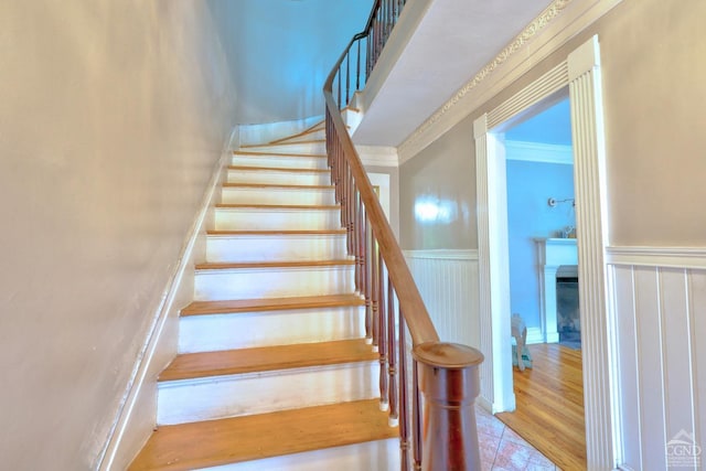 stairs featuring crown molding and hardwood / wood-style floors