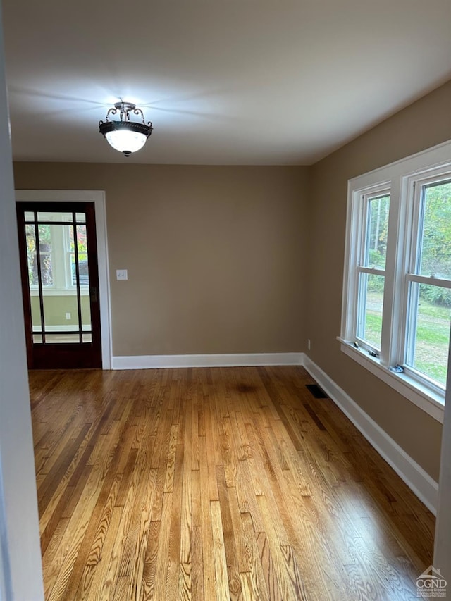 unfurnished room with plenty of natural light and light hardwood / wood-style flooring