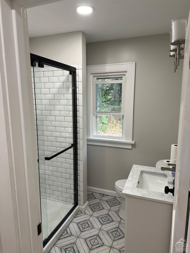 bathroom featuring vanity, toilet, and a shower with door