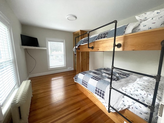 bedroom with wood-type flooring and radiator