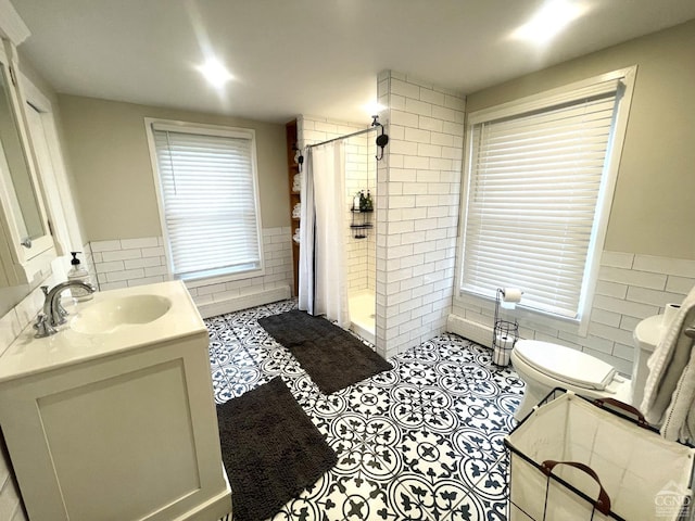 bathroom featuring vanity, a healthy amount of sunlight, and tile walls