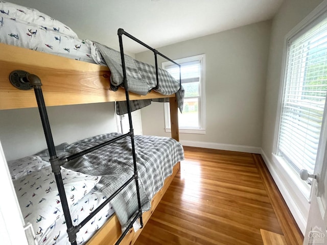 bedroom with hardwood / wood-style flooring and multiple windows