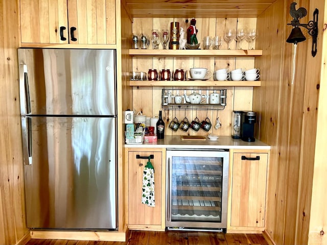 bar featuring light brown cabinets, dark hardwood / wood-style flooring, stainless steel refrigerator, and beverage cooler