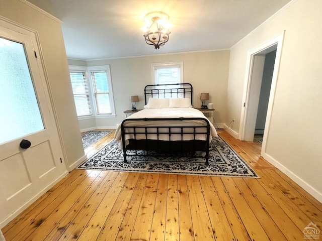 bedroom with hardwood / wood-style flooring, an inviting chandelier, and ornamental molding