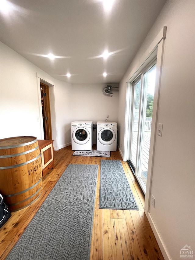 washroom with light hardwood / wood-style flooring and washing machine and clothes dryer