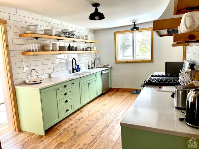 kitchen featuring sink, tasteful backsplash, stainless steel dishwasher, light hardwood / wood-style floors, and green cabinetry