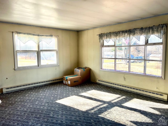 carpeted empty room featuring a baseboard heating unit