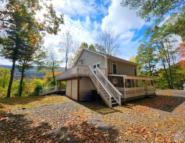 rear view of house with a deck and a sunroom