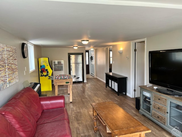 living room with baseboard heating and dark wood-type flooring