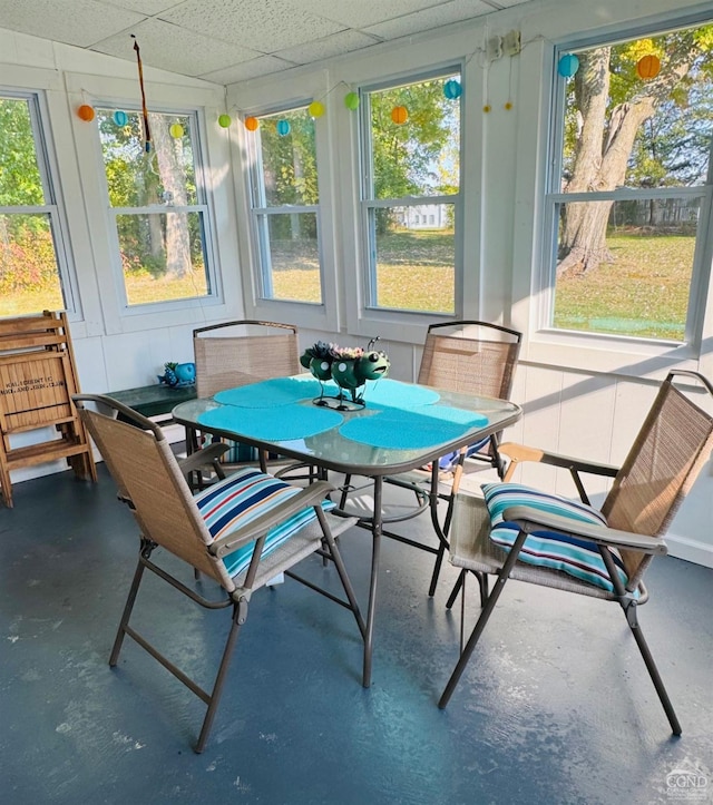 sunroom with a drop ceiling and a healthy amount of sunlight