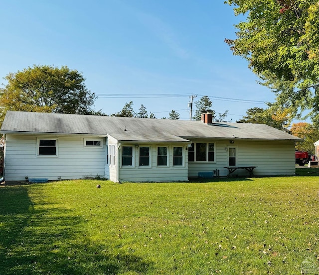 rear view of house featuring a lawn