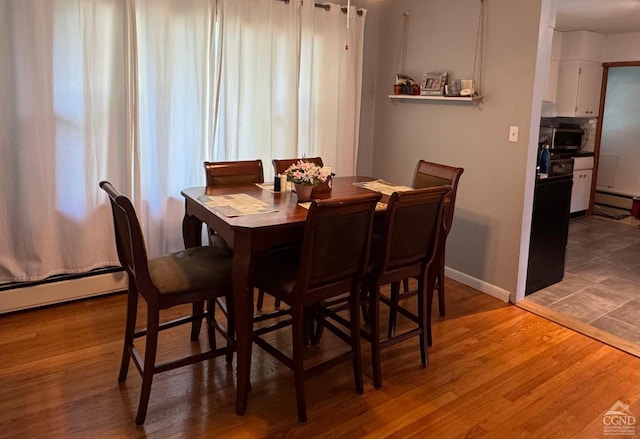 dining space featuring hardwood / wood-style floors and a baseboard radiator