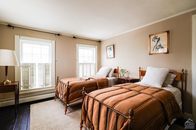 bedroom with a baseboard heating unit, wood finished floors, and crown molding