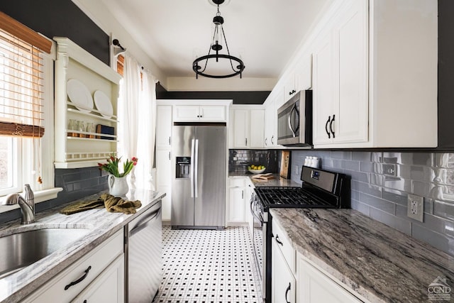 kitchen featuring appliances with stainless steel finishes, white cabinetry, a sink, and light floors