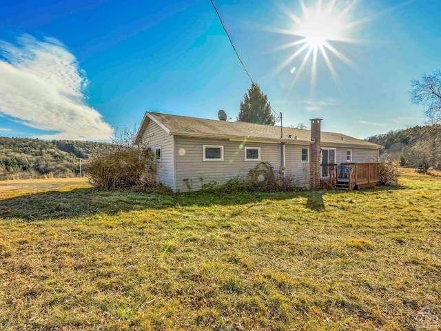 rear view of house with a yard and a deck