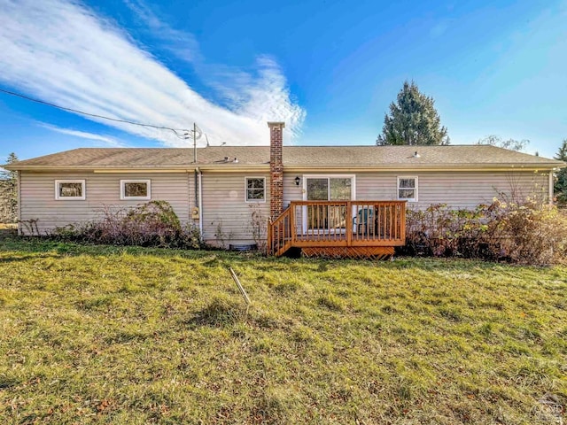 rear view of house featuring a wooden deck and a yard