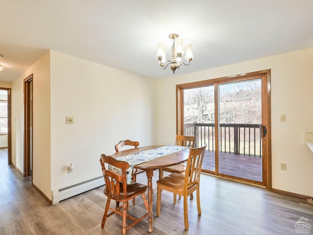 dining area featuring light hardwood / wood-style floors, an inviting chandelier, and a baseboard radiator