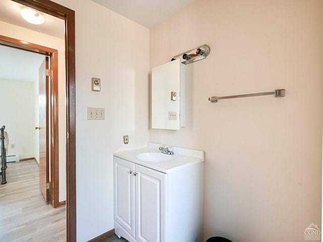 bathroom featuring vanity, wood-type flooring, and a baseboard heating unit