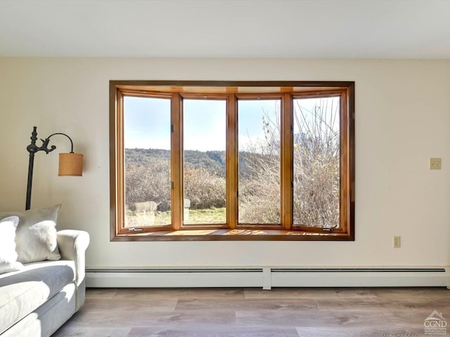 interior space with a baseboard heating unit and light wood-type flooring