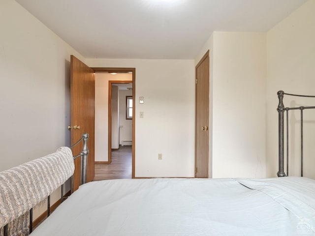 bedroom featuring hardwood / wood-style flooring and a baseboard radiator