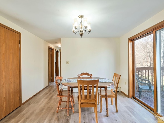 dining area with light wood-type flooring and a notable chandelier