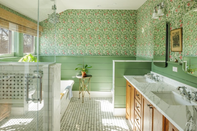 full bathroom with a tub to relax in, double vanity, a sink, and wallpapered walls