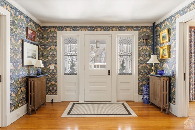 entryway with wallpapered walls, radiator heating unit, and wood finished floors