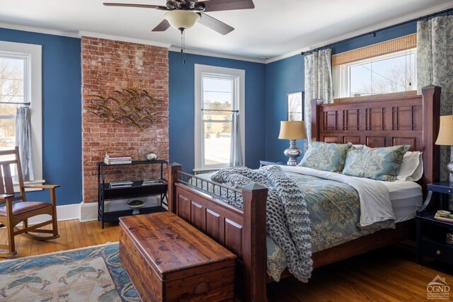 bedroom with baseboards, wood finished floors, and crown molding