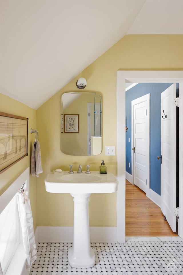 bathroom with baseboards and vaulted ceiling