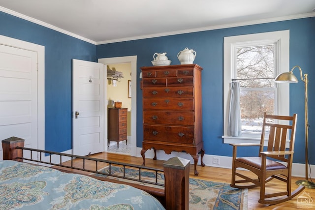 bedroom featuring ornamental molding, baseboards, and wood finished floors