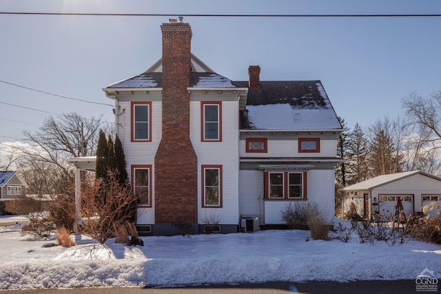 view of front of house with a chimney, central AC unit, and an outdoor structure