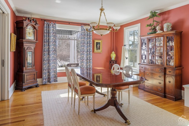 dining area featuring ornamental molding and light wood finished floors