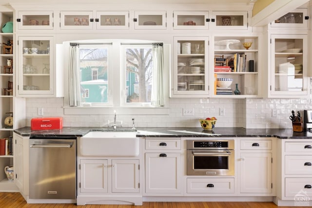 kitchen featuring appliances with stainless steel finishes, glass insert cabinets, and open shelves