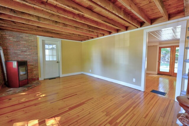 unfurnished living room with beam ceiling, a wealth of natural light, light hardwood / wood-style floors, and wooden ceiling